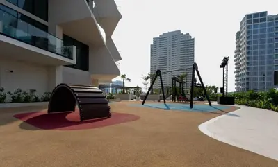 a playground in front of a building with two swings at Exclusive 1BR W Private Pool Binghatti Royale in Dubai