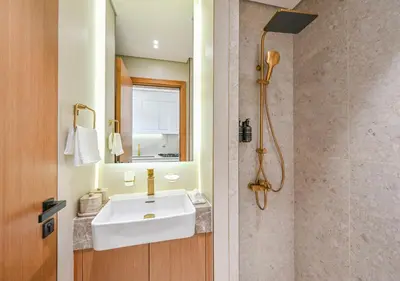 a bathroom with a white sink and a shower at Stylish JVC Studio Hotel-Style Comfort in Dubai