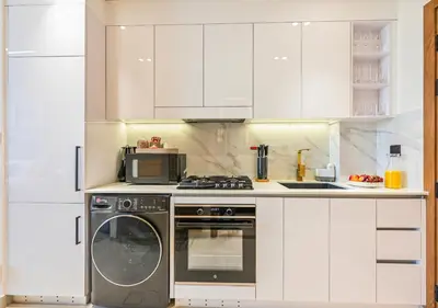 a kitchen with a washing machine and a microwave at Stylish JVC Studio Hotel-Style Comfort in Dubai