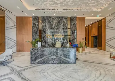 a lobby with a marble counter in the middle at Stylish JVC Studio Hotel-Style Comfort in Dubai