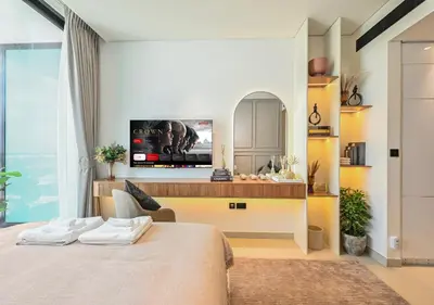 a bedroom with a bed and a tv on a wall at Stylish JVC Studio Hotel-Style Comfort in Dubai