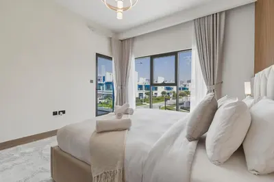 a white bedroom with a large bed with white pillows at Five-Bedroom plus maid's room villa with Multiple En-Suites Sunset Roof Terraces & Exceptional Space in Dubai