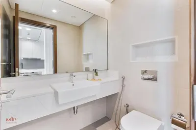 a white bathroom with a sink and a mirror at Canal-Side Living Elegant 2BR at Canal Front in Dubai