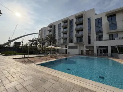 a swimming pool in front of a large building at Canal-Side Living Elegant 2BR at Canal Front in Dubai