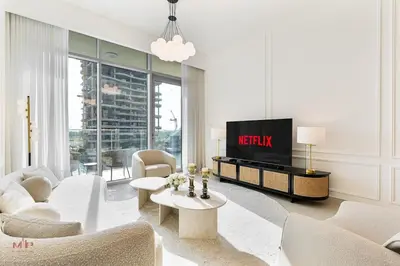 a living room with white furniture and a tv at Canal-Side Living Elegant 2BR at Canal Front in Dubai