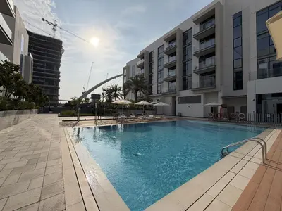 a large swimming pool in front of a building at Canal-Side Living Elegant 2BR at Canal Front in Dubai