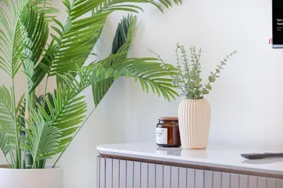 a white vase sitting on a table with two plants at Beachfront stay at Beach Mansion with Private Beach in Dubai