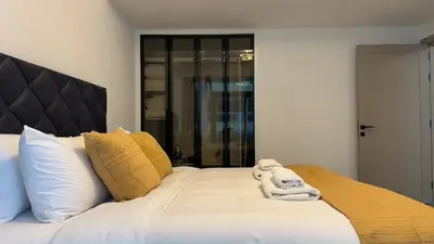 a white bed with towels on top of it at 1BDR Centrally Located Near Metro in Dubai