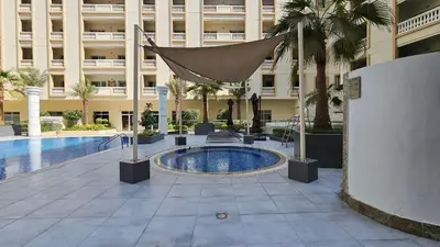 a courtyard with a swimming pool in a building at StayShort - Modern JVC 1 bed Sleeps 4 with Swimming Pool in Dubai