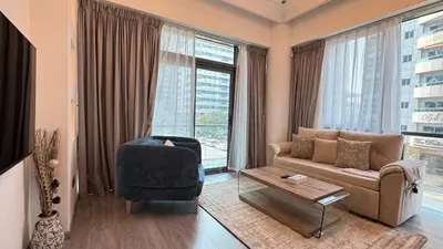 a living room with a couch and a chair at 1BDR Centrally Located Fully Equipped Kitchen in Dubai