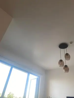 two lights hanging from a ceiling next to a window at La Cote, free Beach access in Dubai