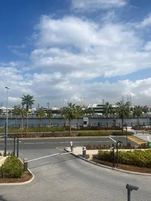 a parking lot with palm trees and a body of water at La Cote, free Beach access in Dubai