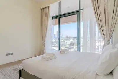 a bedroom with a bed and a large window at TRPS - Azizi Riviera 5, Al Meydan - Modern Luxury 1BR, Minutes to Burj Khalifa in Dubai