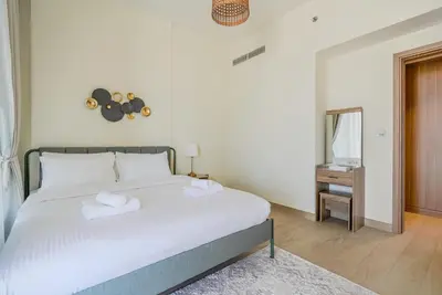 a bedroom with a large white bed with a mirror at TRPS - Azizi Riviera 5, Al Meydan - Modern Luxury 1BR, Minutes to Burj Khalifa in Dubai