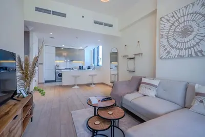a living room with a couch and two tables at TRPS - Azizi Riviera 5, Al Meydan - Modern Luxury 1BR, Minutes to Burj Khalifa in Dubai