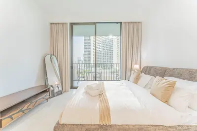 a bedroom with a white bed and a large window at HAVN - 1 bed in Luma Parks, JVC in Dubai