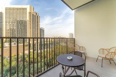 a balcony with a table and chairs and a view of the city at HAVN - 1 bed in Luma Parks, JVC in Dubai