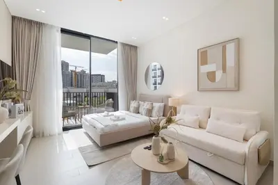 a white living room with a bed and a couch at Boutique Studio at Binghatti Aurora by Czechin in Dubai