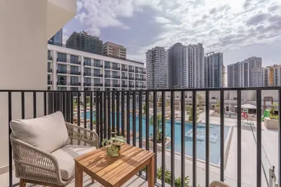 a balcony with a chair and a table and a pool at Boutique Studio at Binghatti Aurora by Czechin in Dubai