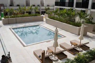 an overhead view of a swimming pool with chairs and umbrellas at Boutique Studio at Binghatti Aurora by Czechin in Dubai