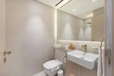 a bathroom with a sink and a toilet and a mirror at Boutique Studio at Binghatti Aurora by Czechin in Dubai