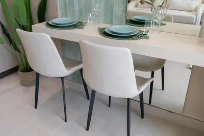 a white dining room table with white chairs and plates at Boutique Studio at Binghatti Aurora by Czechin in Dubai
