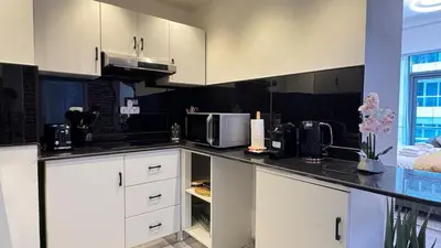 a kitchen with white cabinets and a microwave at Studio Centrally Located Near to Metro in Dubai