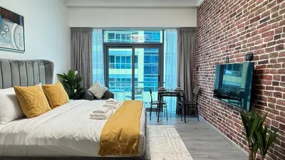 a bedroom with a bed and a brick wall at Studio Centrally Located Near to Metro in Dubai