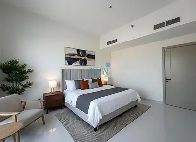 a bedroom with a large bed and a chair at Modern 1BHK Equiti Arcade- Al Furjan -Near Metro in Dubai