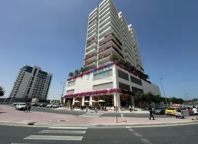 a tall building with flowers on it on a city street at Modern 1BHK Equiti Arcade- Al Furjan -Near Metro in Dubai