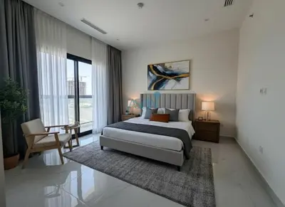 a bedroom with a bed and a table and a chair at Modern 1BHK Equiti Arcade- Al Furjan -Near Metro in Dubai