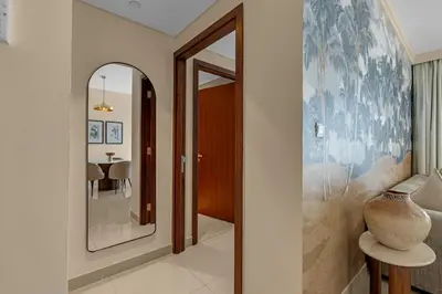 a hallway with a mirror and a vase on a table at Waves - Luxury 2BR Apt With Burj Khalifa & Fountain View in Dubai