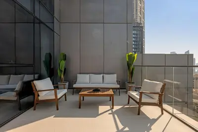 a living room with chairs and a table on a building at Waves - Luxury 2BR Apt With Burj Khalifa & Fountain View in Dubai