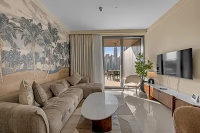 a living room with a couch and a tv at Waves - Luxury 2BR Apt With Burj Khalifa & Fountain View in Dubai