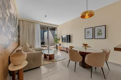 a living room with a couch and a table at Waves - Luxury 2BR Apt With Burj Khalifa & Fountain View in Dubai