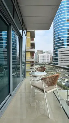 a balcony with a table and chairs on a building at 1 Bedroom Centrally located near the Metro in Dubai