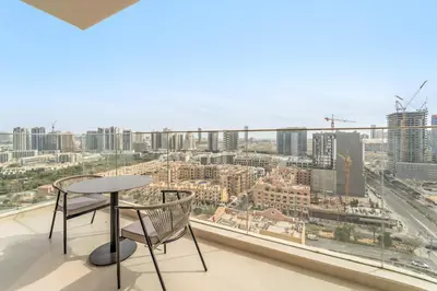 a balcony with a table and chairs and a view of a city at VayK - Bright Modern Apartment in JVC - 1BR Gem in Dubai