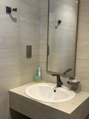 a bathroom with a white sink and a mirror at Stylish 2BR in Business Bay with all essentials in Dubai