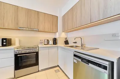 a small kitchen with white cabinets and a sink at Bright 1BR in Executive Residences 2, Dubai Hills in Dubai