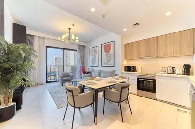 a kitchen and living room with a table and chairs at Bright 1BR in Executive Residences 2, Dubai Hills in Dubai
