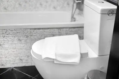 a bathroom with a toilet with two towels on it at Modern 2BDR Stay-Near Metro-Al Furjan in Dubai