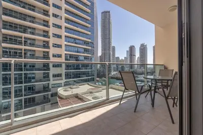 a balcony with a table and chairs and a view of a city at Modern 1BHK Jewels Tower, Dubai Marina by Czechin in Dubai