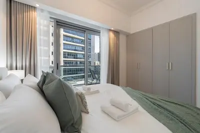 a bedroom with a white bed with a large window at Modern 1BHK Jewels Tower, Dubai Marina by Czechin in Dubai