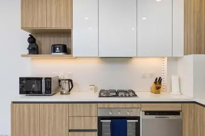 a kitchen with white cabinets and a stove top oven at VayK - Extra-Large 2BR in Dubai Hills Close to Mall & Park in Dubai