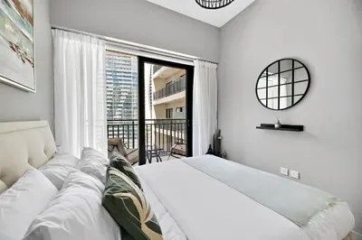 a white bedroom with a bed and a large window at VayK - Newly Launched 1BR in Business Bay in Dubai