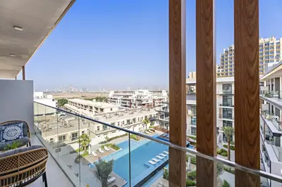 a balcony with a view of a pool and buildings at VayK - Contemporary 1BR in a New JVC Community in Dubai