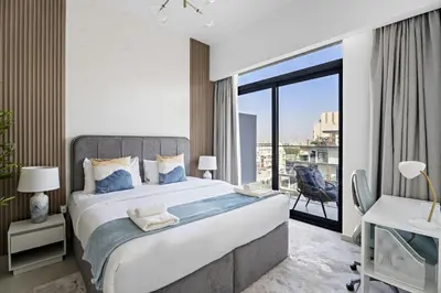 a bedroom with a large bed and a large window at VayK - Contemporary 1BR in a New JVC Community in Dubai