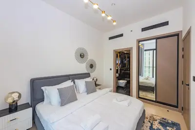 a bedroom with a large bed and a mirror at VayK - Chic 1BR Urban Getaway in Dubai