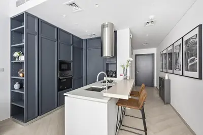 a kitchen with black cabinets and a white counter top at VayK - Ideal Studio in Sobha Hartland in Dubai