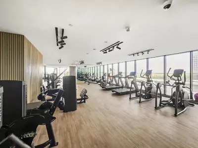 a gym with a row of treadmills and machines at VayK - Comfortable 1BR in JVC in Dubai